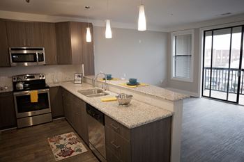 A kitchen with a granite countertop and stainless steel appliances at West Inman Lofts Apartments, Georgia, 30312